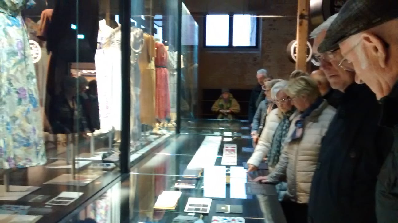 Besucher an der Vitrine mit den historischen Kleidungsstücken
